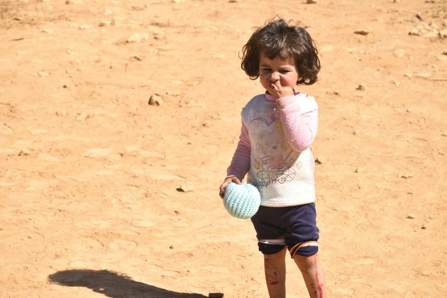 A little girl holds a small ball